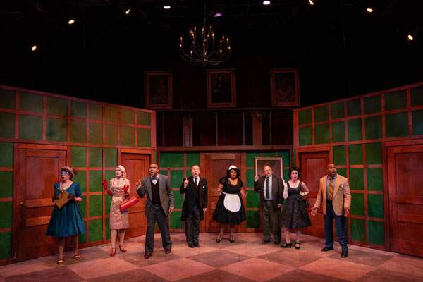 stage showing eight adults dressed as various characters from the play based on the Clue board game